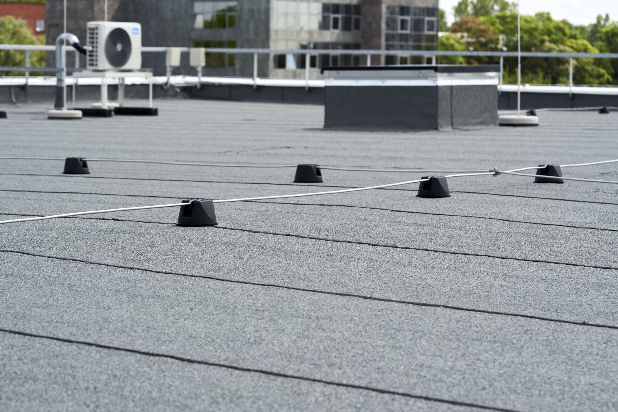 Flat roof covered with bitumen membrane for waterproofing.